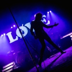 Photo de Julien Doré pour le LØVE Tour devant le logo LØVE sur un fond éclairé de bleu